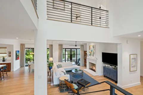 a living room with furniture a flat screen tv and a refrigerator