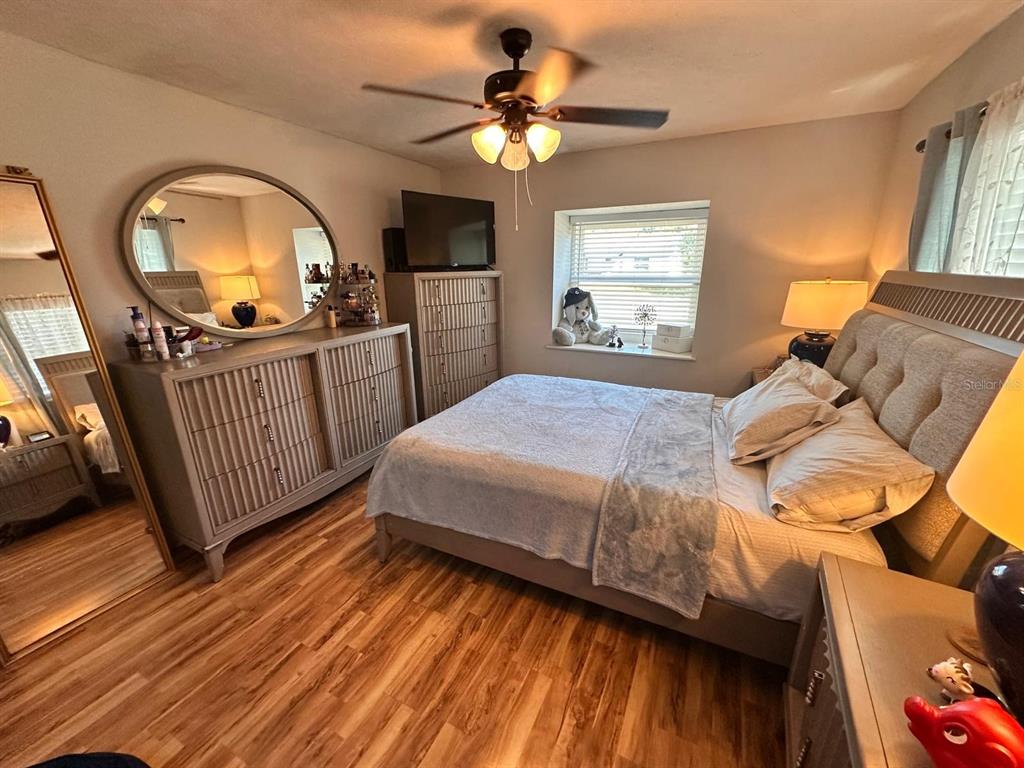 613 Royal Crest Way Brandon, FL 33511 - Photo 13 of 50 a bedroom with a bed a mirror on dresser and a wooden floor