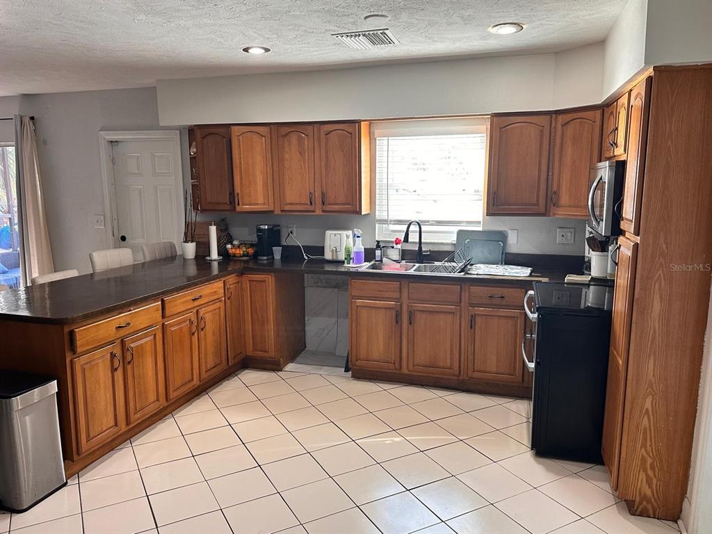 613 Royal Crest Way Brandon, FL 33511 - Photo 39 of 50 a kitchen with a sink a stove top oven a refrigerator and cabinets