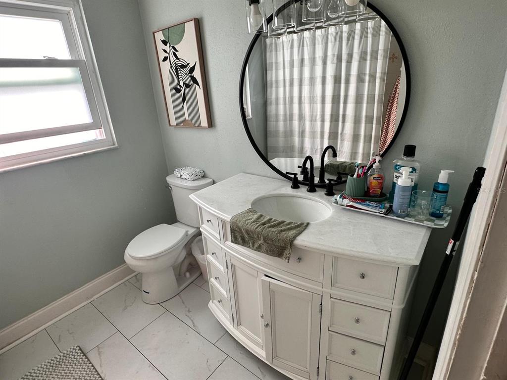 613 Royal Crest Way Brandon, FL 33511 - Photo 5 of 50 a bathroom with a toilet a sink a mirror and a window