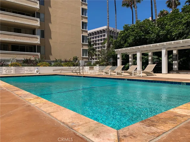 a view of a swimming pool with a chair and tables in the patio