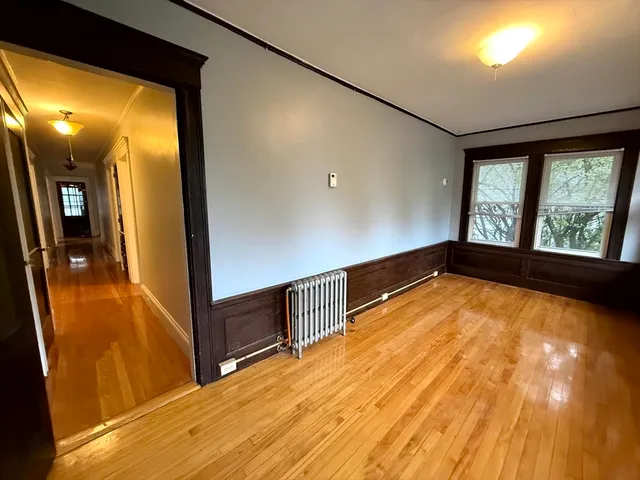 a view of a hallway with wooden floor and staircase