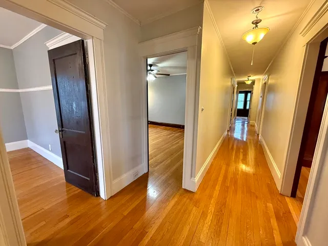 a view of a hallway with wooden floor and staircase