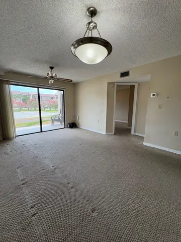 an empty room with windows and fireplace