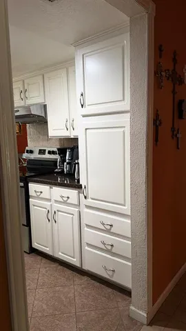 a kitchen with white cabinets and white appliances