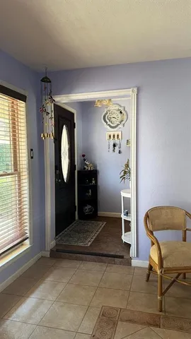 a view of a livingroom with wooden floor and a chair