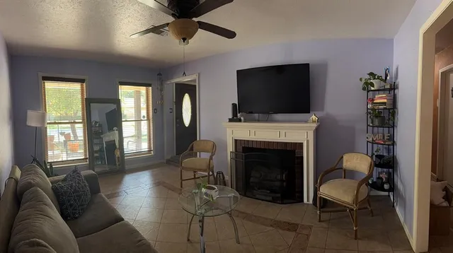 a living room with furniture a flat screen tv and a fireplace