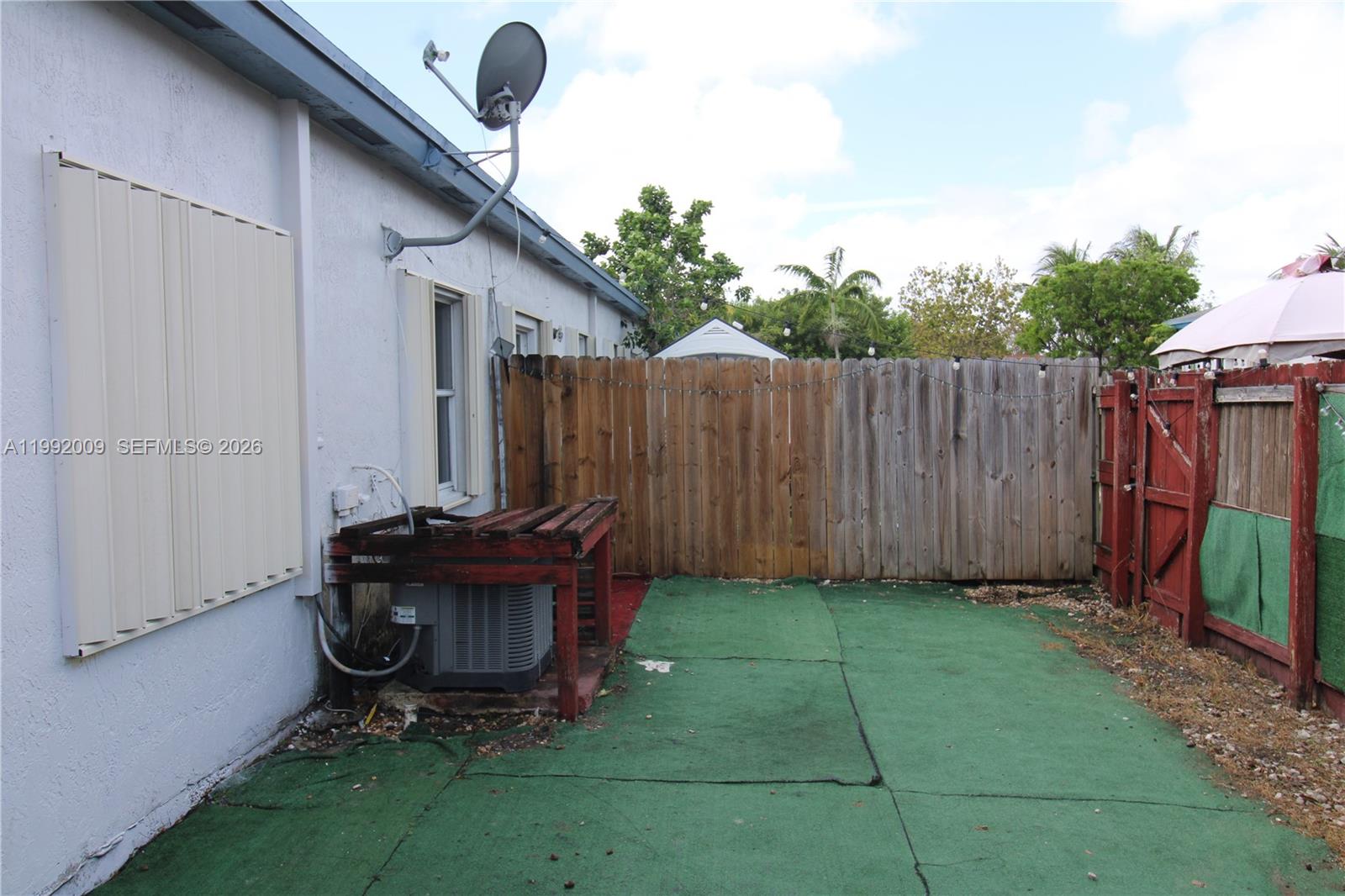 13929 Southwest 282nd Street Homestead, FL 33033 - Photo 26 of 30 a view of backyard with table and chairs and wooden fence