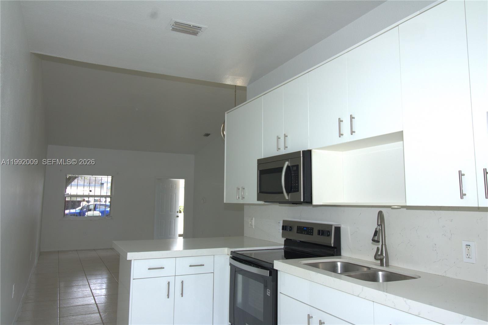 13929 Southwest 282nd Street Homestead, FL 33033 - Photo 9 of 30 a kitchen with stainless steel appliances white cabinets and a sink