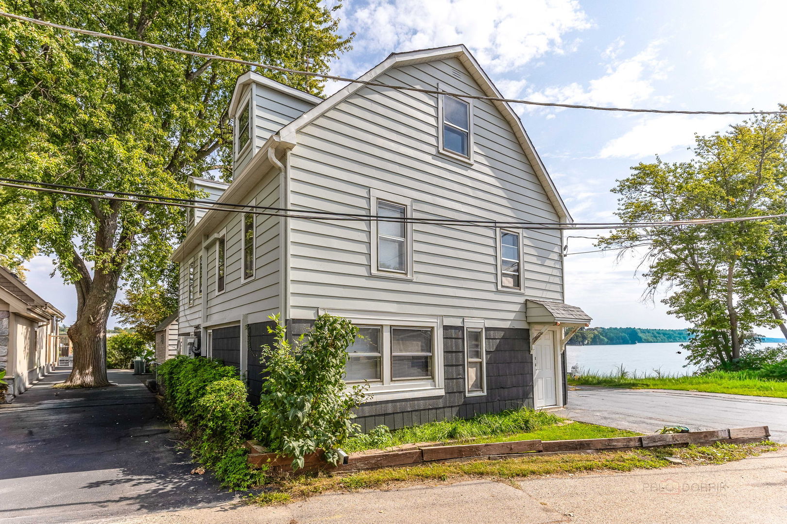 163 Eagle Point Road, Unit 1 Fox Lake, IL 60020 - Photo 4 of 26 a view of a white house next to a road and yard