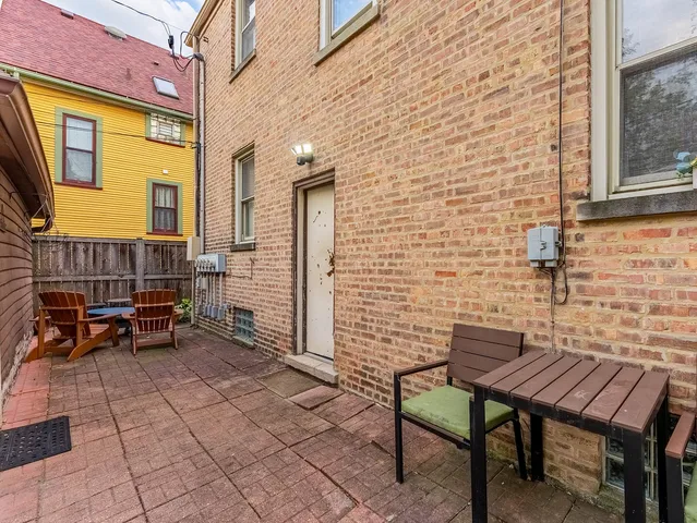a brick house with table and chairs in front of it