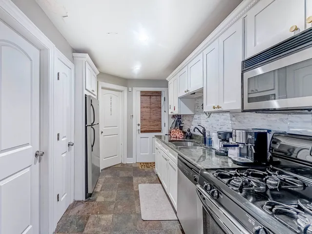 a kitchen with stainless steel appliances granite countertop a stove and a refrigerator