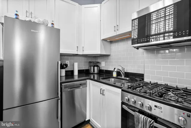 a kitchen with stainless steel appliances granite countertop a refrigerator stove top oven and sink