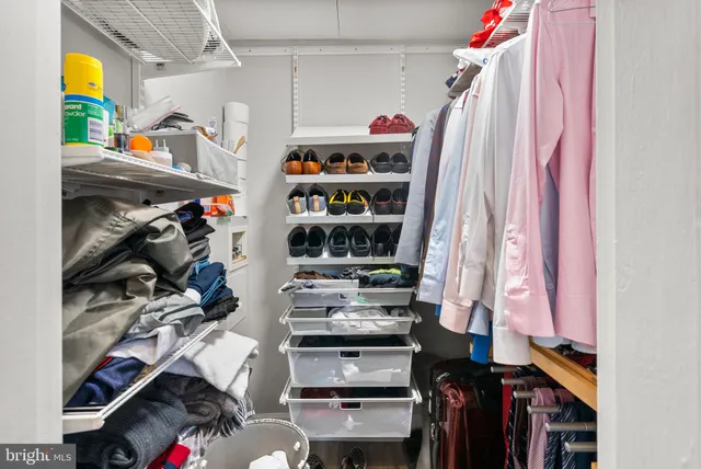 a view of walk in closet with clothes and shoes
