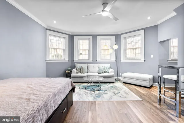 a spacious bedroom with a bed a couch and a window