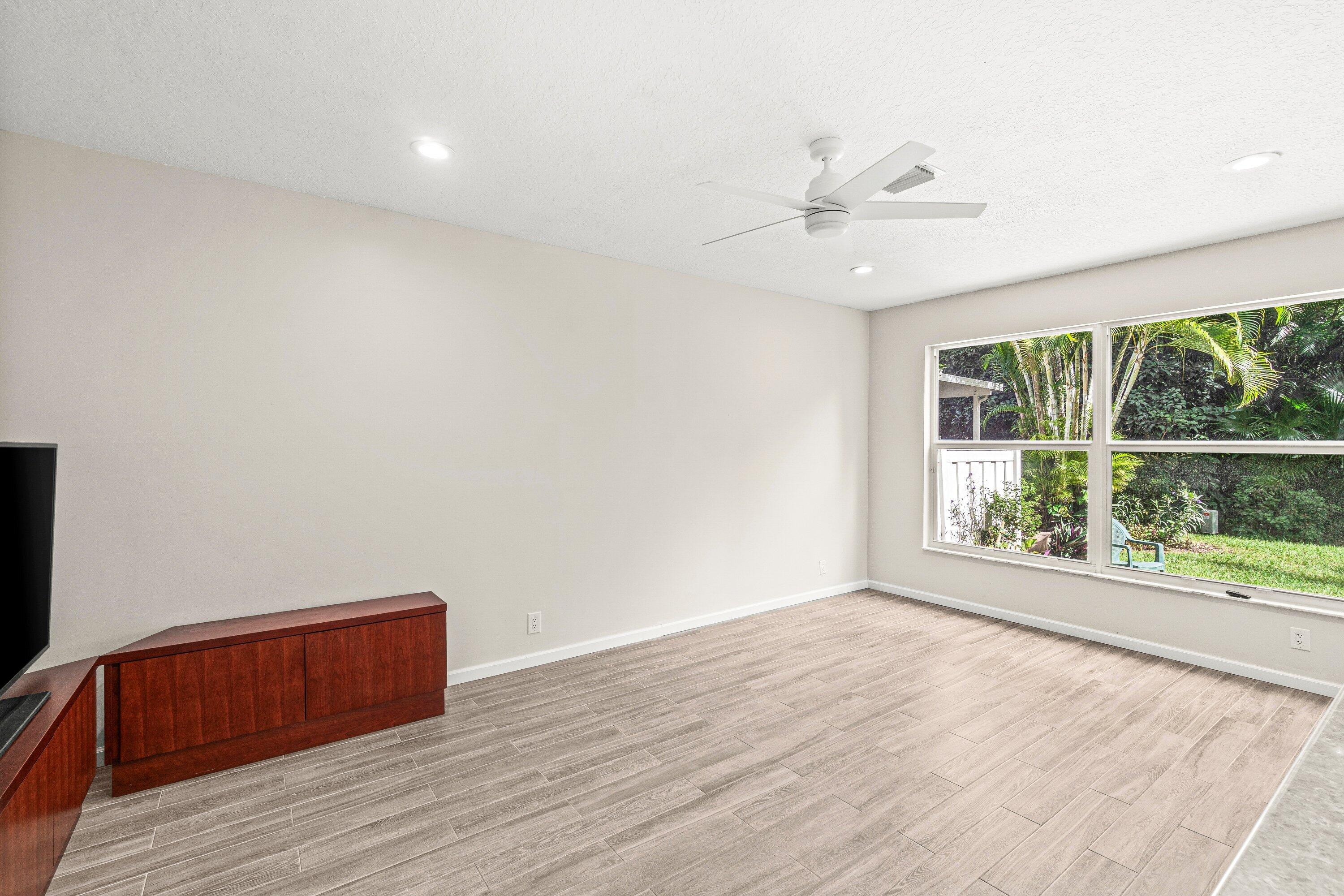 21256 Vía Fiore Boca Raton, FL 33433 - Photo 13 of 42 an empty room with wooden floor and windows