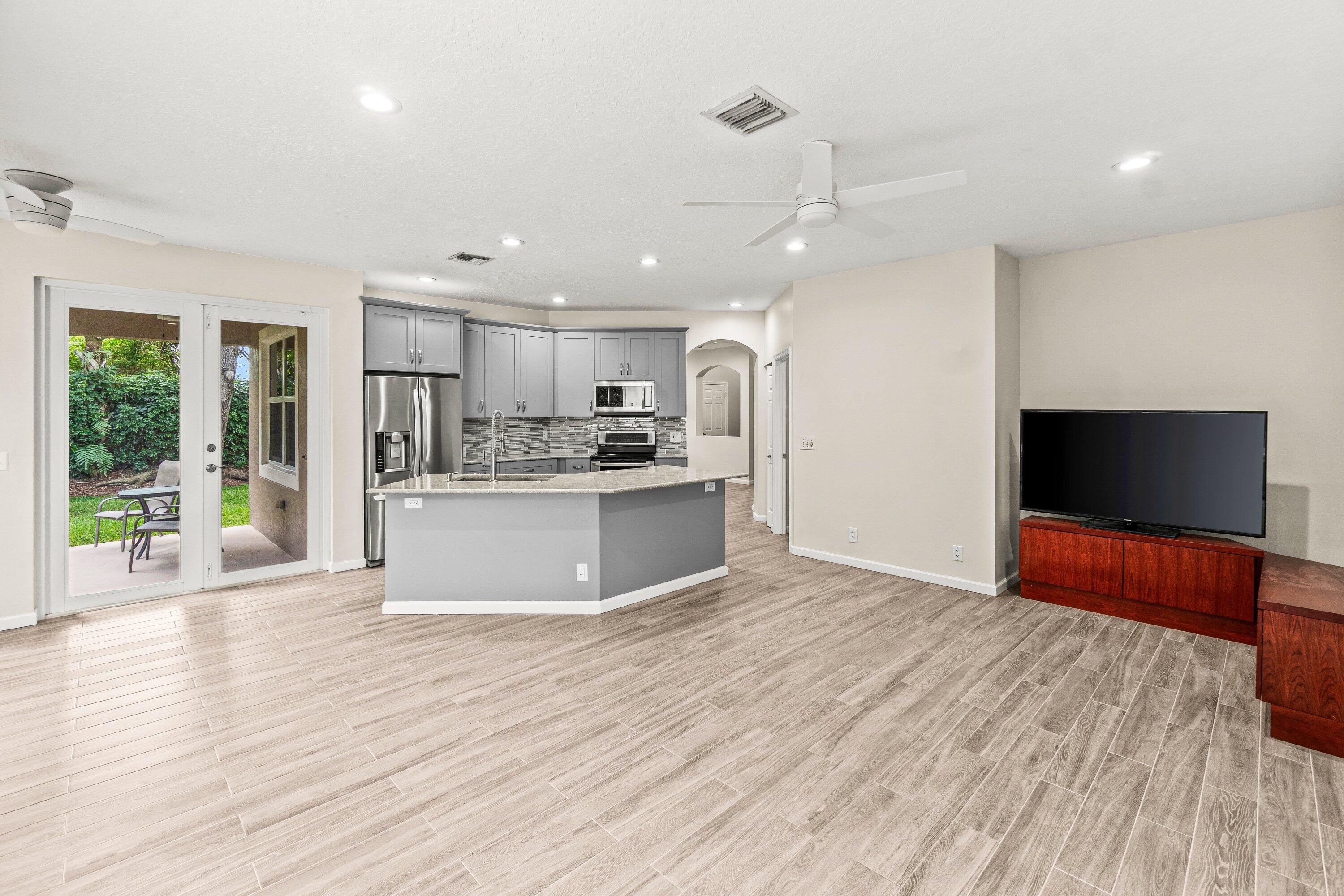 21256 Vía Fiore Boca Raton, FL 33433 - Photo 14 of 42 a view of kitchen with refrigerator microwave and wooden floor