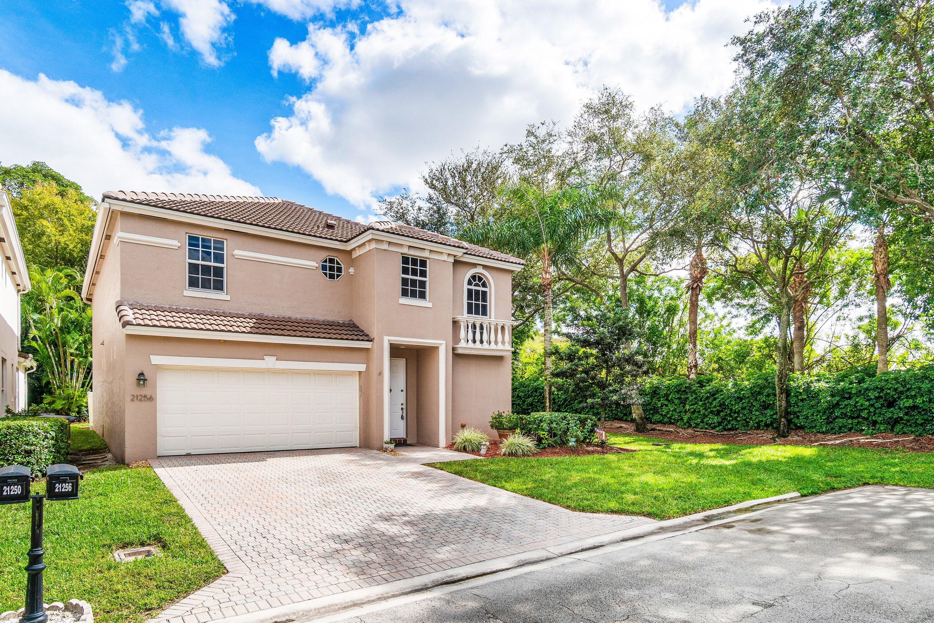 21256 Vía Fiore Boca Raton, FL 33433 - Photo 2 of 42 a front view of a house with a yard and garage