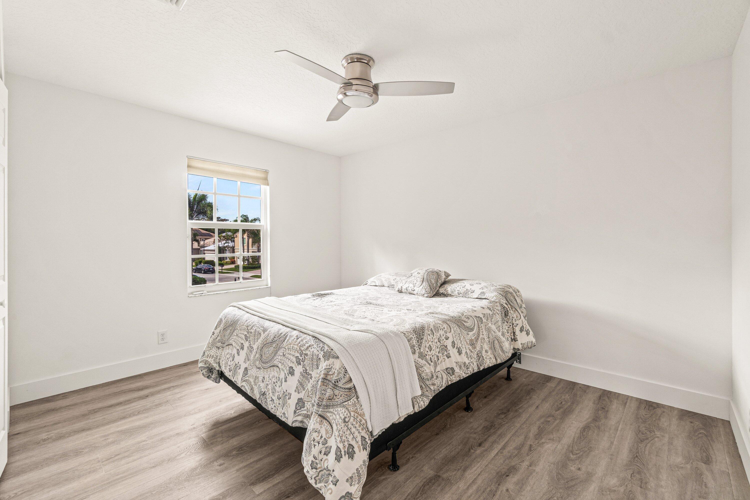 21256 Vía Fiore Boca Raton, FL 33433 - Photo 22 of 42 a bedroom with a bed and a window