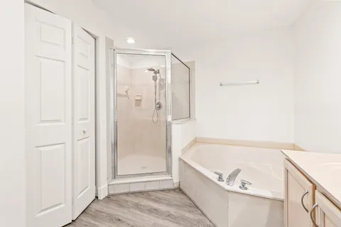 a bathroom with a tub shower and hallway