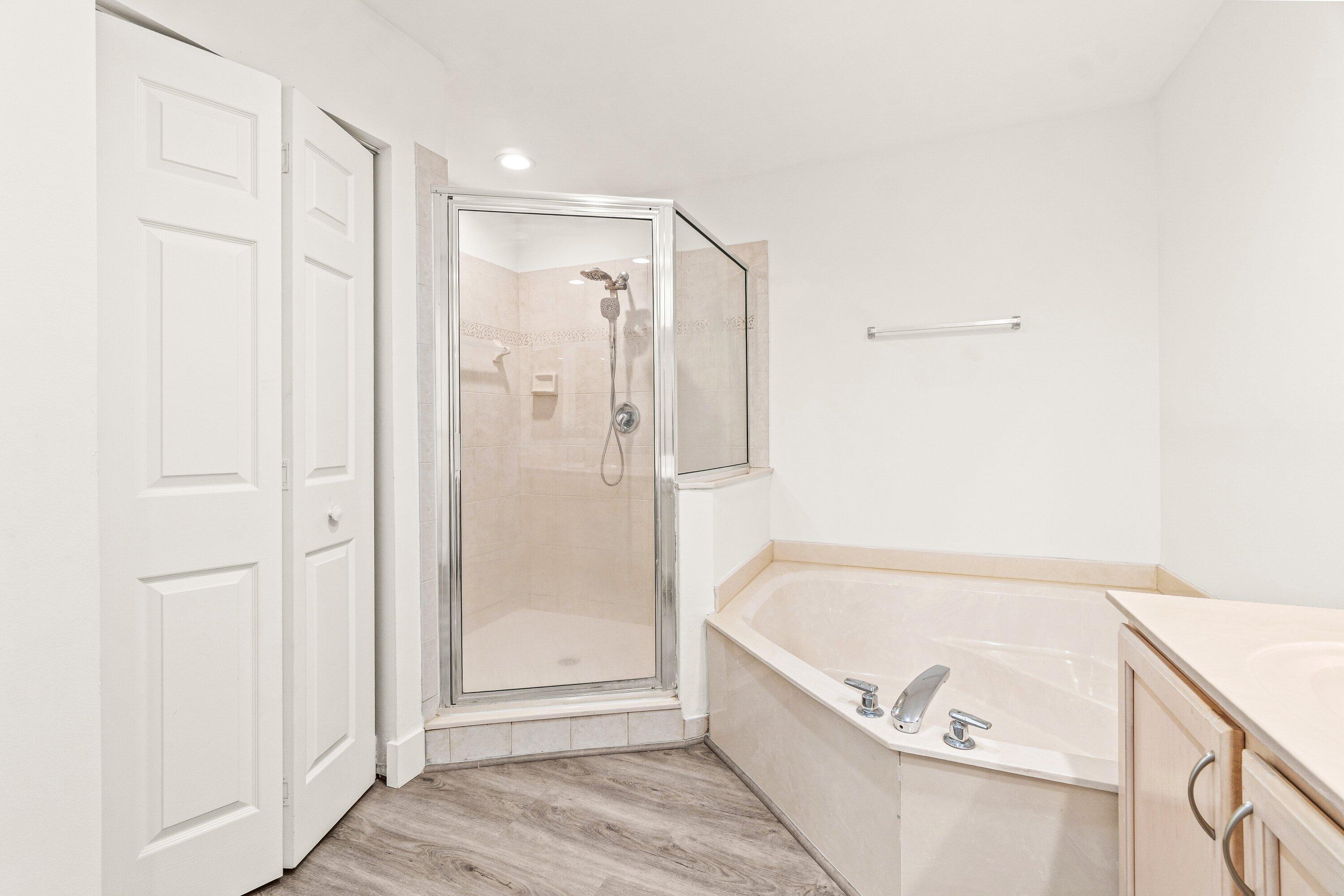 21256 Vía Fiore Boca Raton, FL 33433 - Photo 29 of 42 a bathroom with a tub shower and hallway