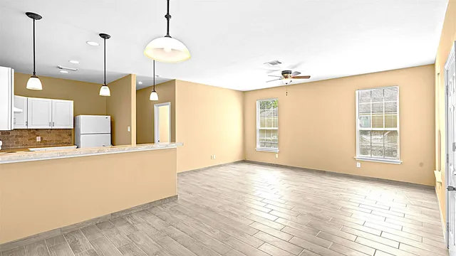 a view of a kitchen with wooden floor and a window