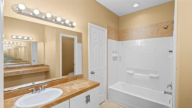 a bathroom with a granite countertop sink a mirror and a bathtub