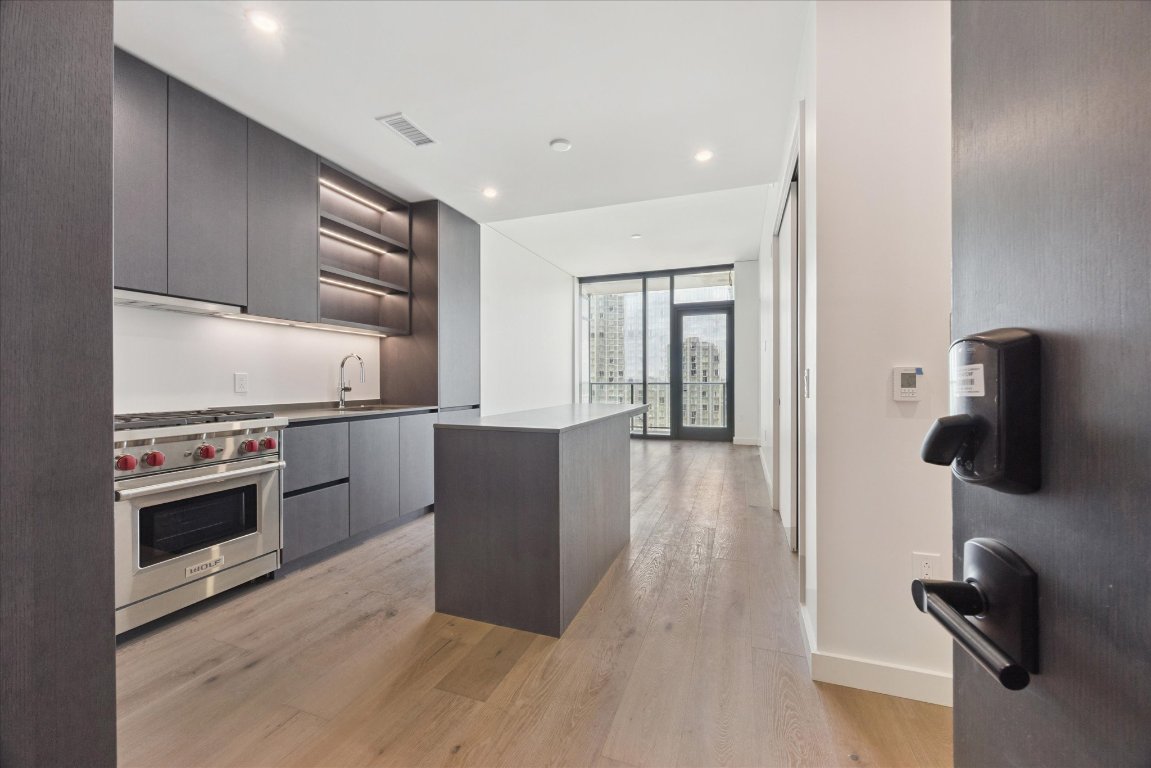 a kitchen with stainless steel appliances granite countertop a refrigerator and a stove top oven