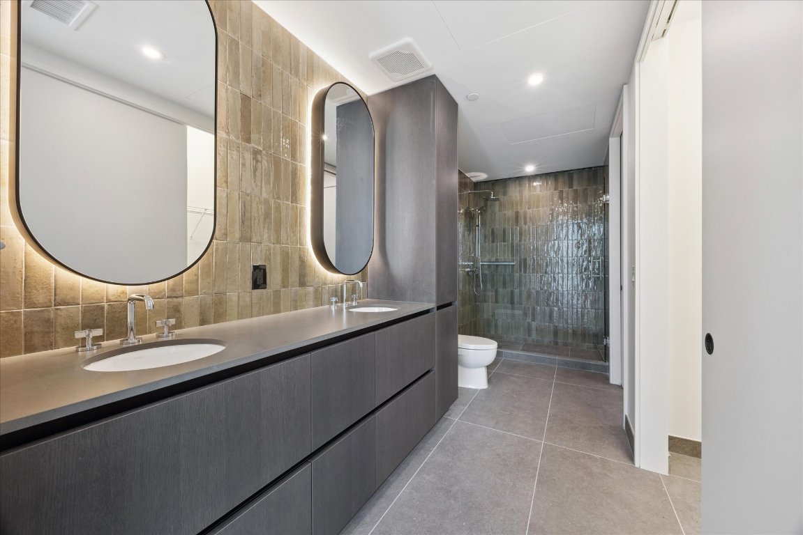 610 Davis Street, Unit 2409 Austin, TX 78701 - Photo 14 of 39 a bathroom with a double vanity sink and a mirror