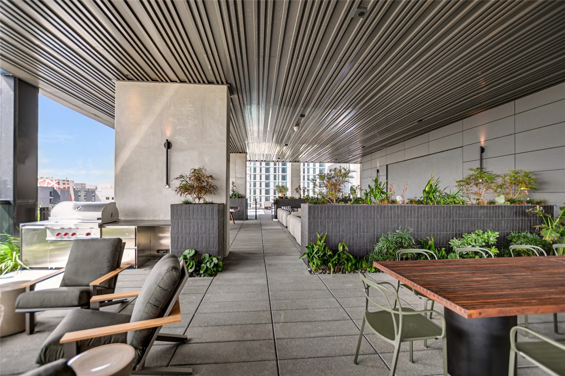 610 Davis Street, Unit 2409 Austin, TX 78701 - Photo 25 of 39 a view of a patio with plants and chairs under an umbrella