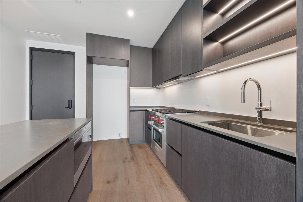 610 Davis Street, Unit 2409 Austin, TX 78701 - Photo 4 of 39 a kitchen with a sink and refrigerator