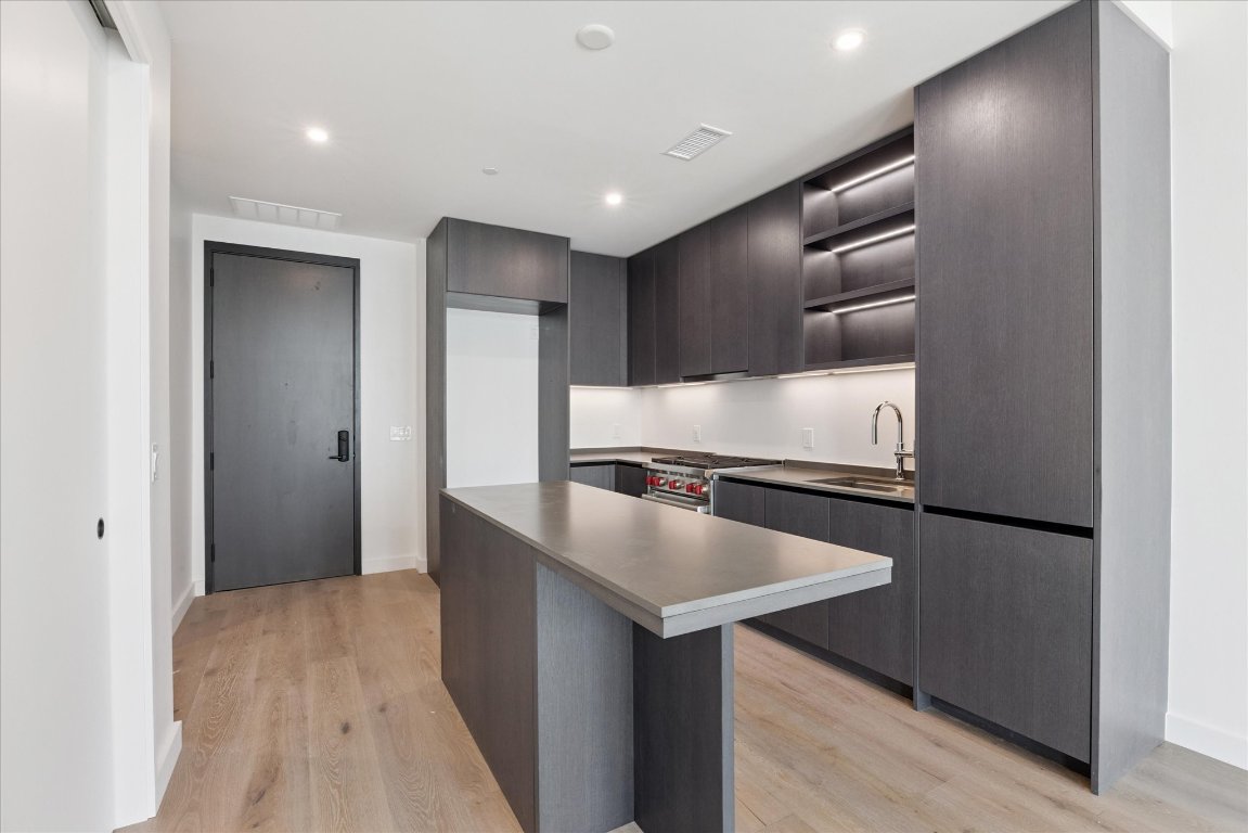 610 Davis Street, Unit 2409 Austin, TX 78701 - Photo 6 of 39 a kitchen with stainless steel appliances granite countertop a sink and a refrigerator