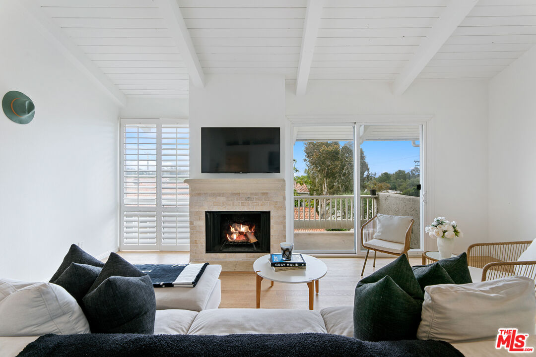 28398 Rey De Copas Lane Malibu, CA 90265 - Photo 13 of 44 a living room with furniture a flat screen tv and a fireplace