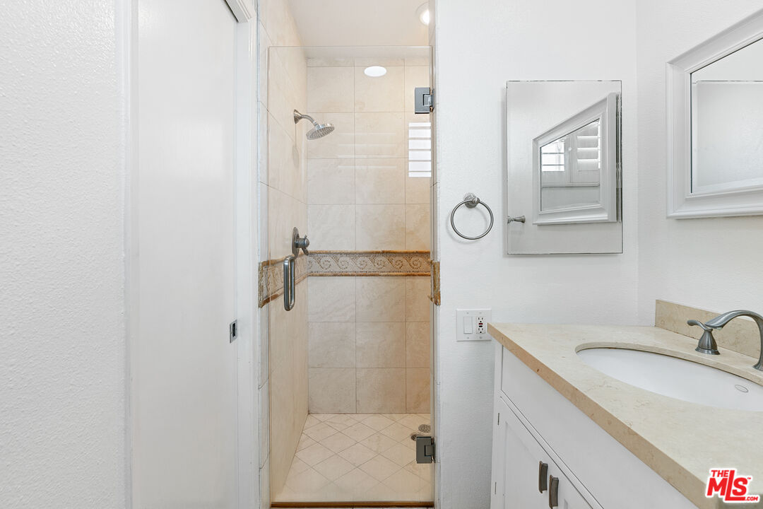 28398 Rey De Copas Lane Malibu, CA 90265 - Photo 37 of 44 a bathroom with a granite countertop shower sink and mirror