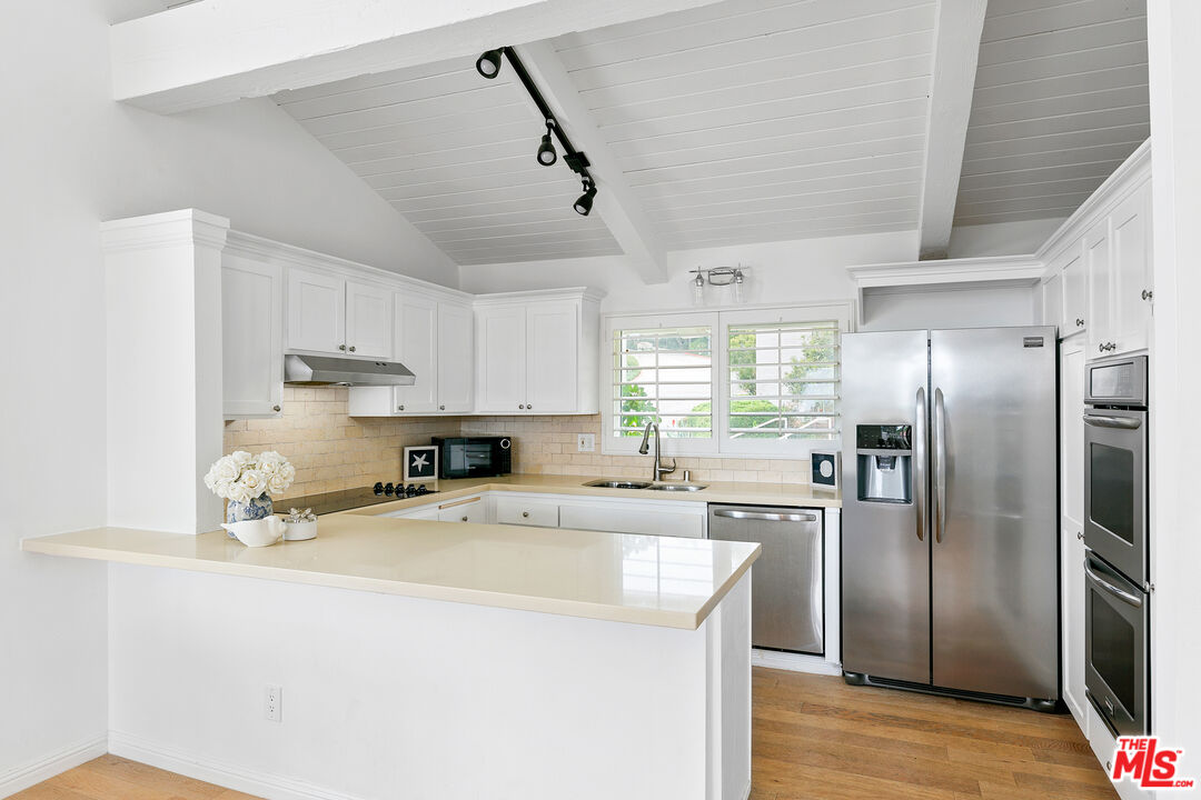 28398 Rey De Copas Lane Malibu, CA 90265 - Photo 7 of 44 a kitchen with stainless steel appliances a refrigerator sink and microwave