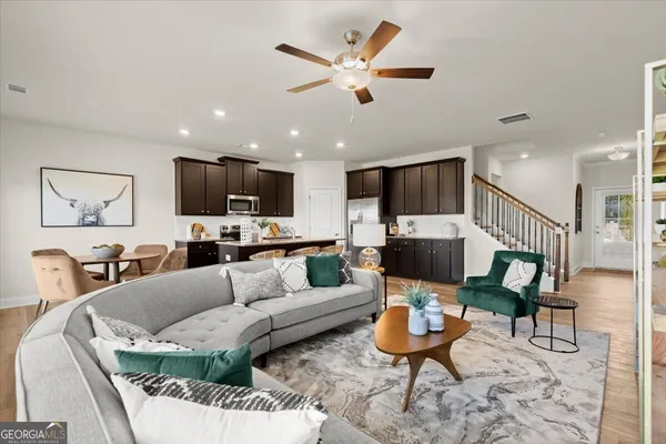 a living room with furniture kitchen view and a flat screen tv