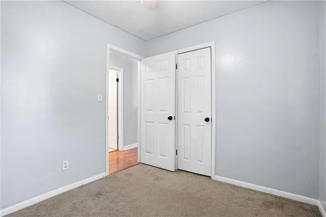 an empty room with a window and ceiling fan