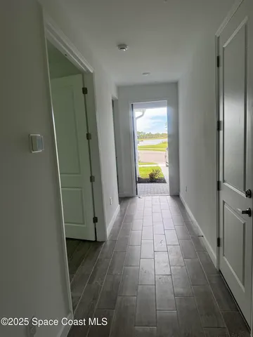 a view of empty room with wooden floor