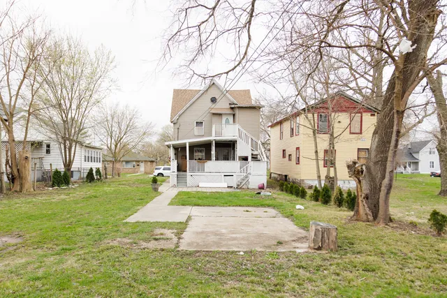a front view of a house with a yard and trees