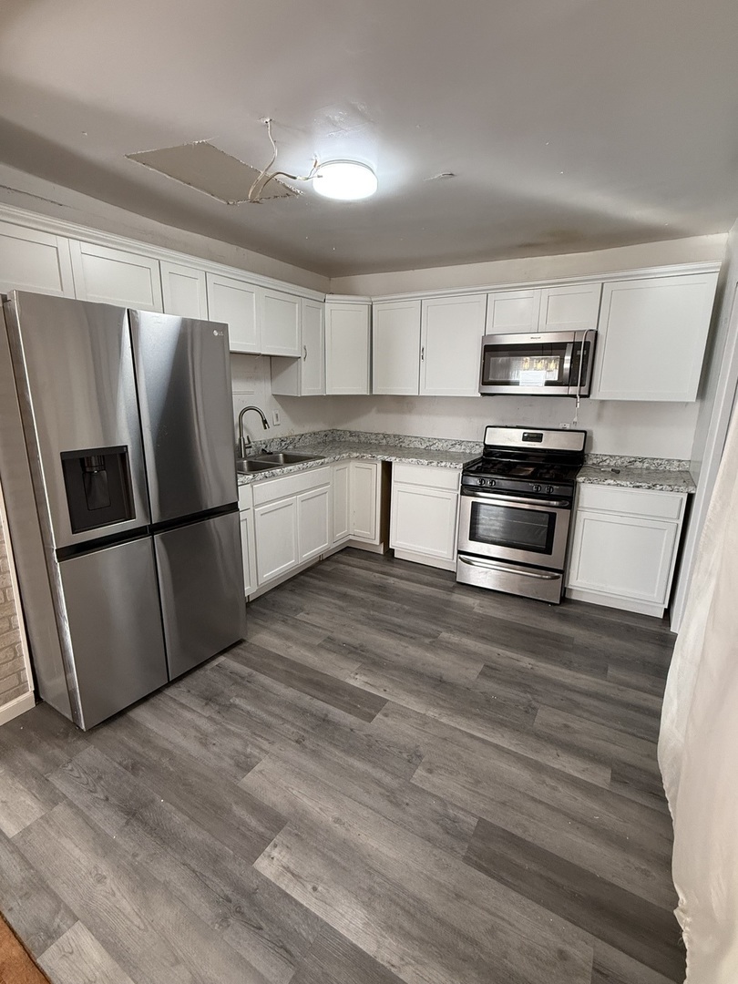 732 North Dearborn Avenue Kankakee, IL 60901 - Photo 3 of 21 a kitchen with granite countertop a refrigerator stove and wooden floor