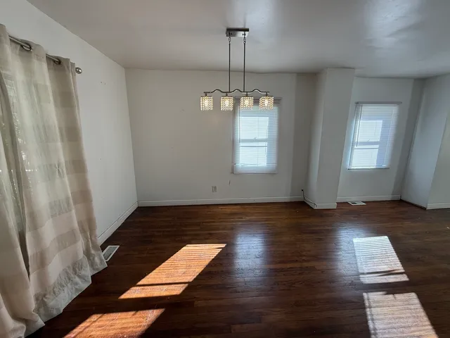 a view of a room with wooden floor and window