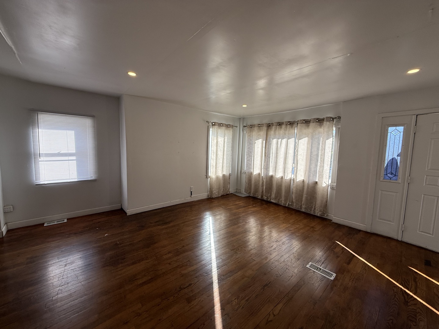 732 North Dearborn Avenue Kankakee, IL 60901 - Photo 8 of 21 an empty room with wooden floor and windows
