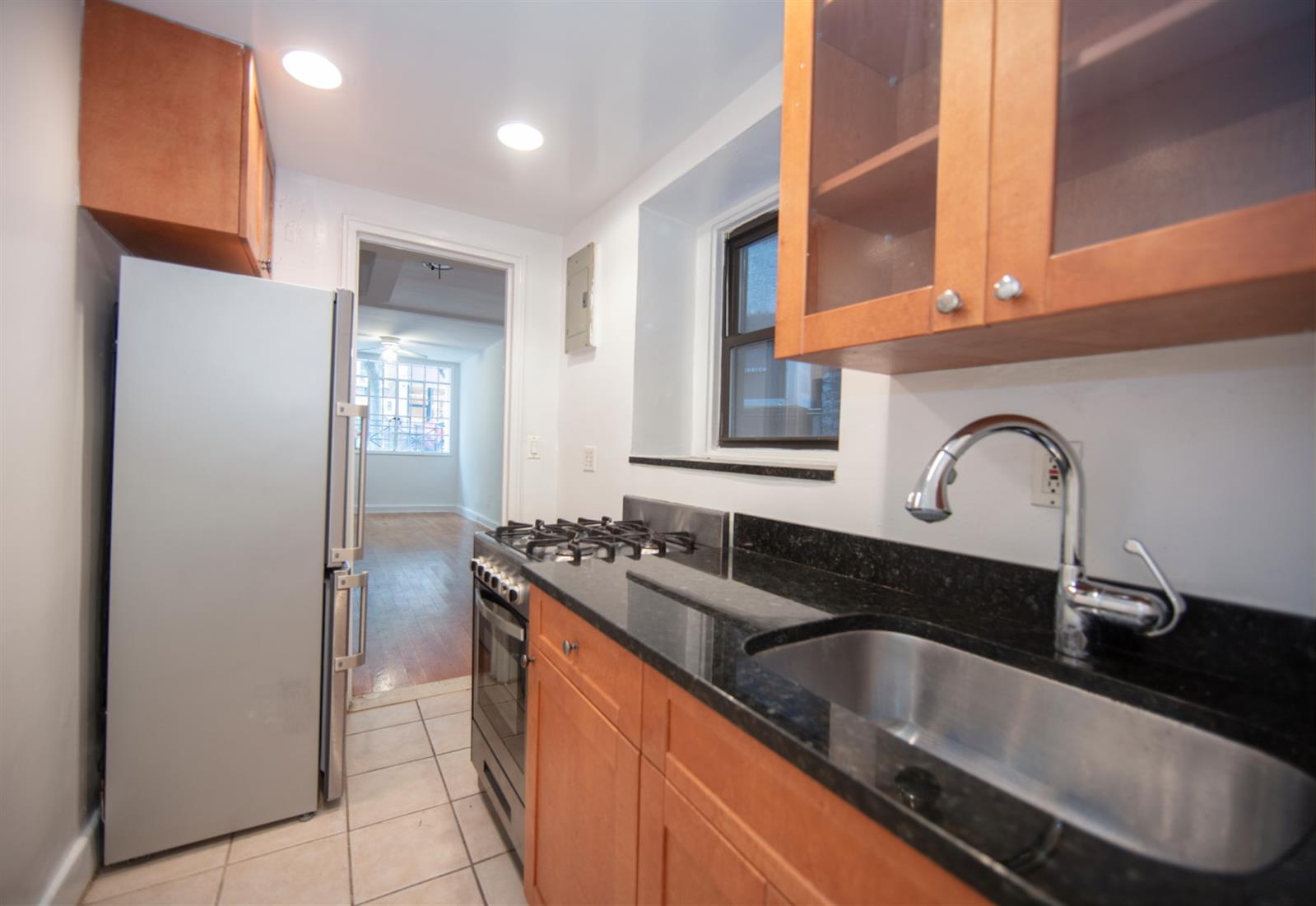 113 Sullivan Street, Unit 20123 Manhattan, NY 10012 - Photo 12 of 15 a kitchen with granite countertop a sink and cabinets