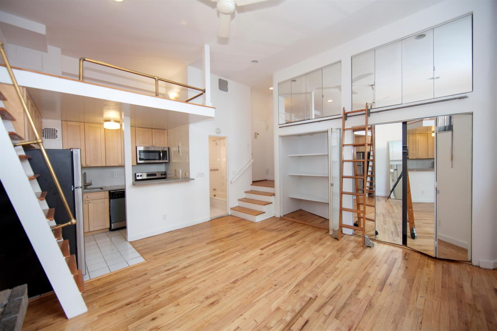 113 Sullivan Street, Unit 20123 Manhattan, NY 10012 - Photo 13 of 15 a view of a kitchen with wooden floor and a sink