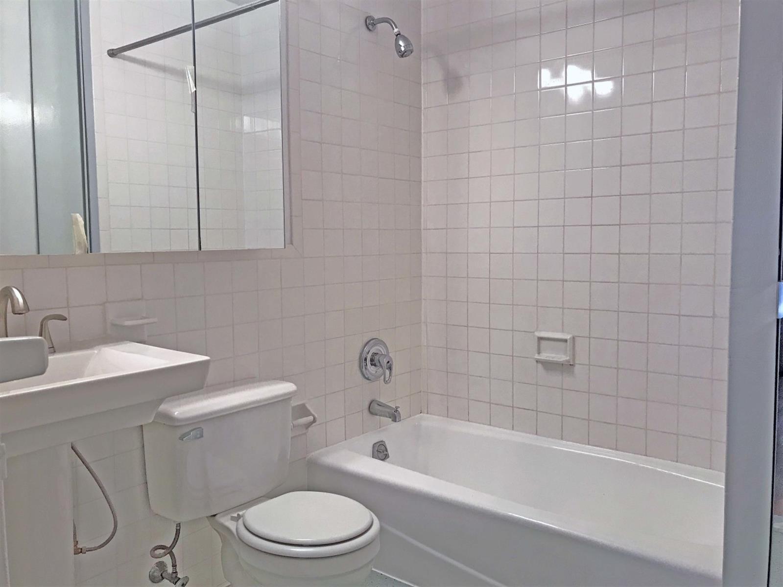 113 Sullivan Street, Unit 20123 Manhattan, NY 10012 - Photo 14 of 15 a bathroom with a toilet a sink and bathtub