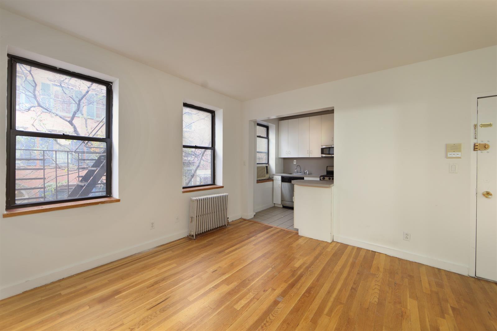 113 Sullivan Street, Unit 20123 Manhattan, NY 10012 - Photo 15 of 15 a view of empty room with wooden floor and fan