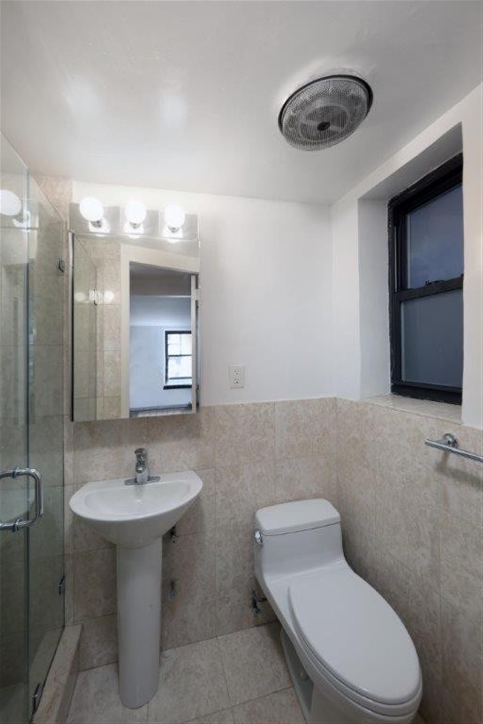 113 Sullivan Street, Unit 20123 Manhattan, NY 10012 - Photo 6 of 15 a bathroom with a toilet sink and mirror