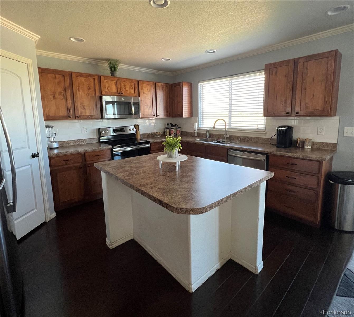 787 Rodgers Circle Platteville, CO 80651 - Photo 4 of 20 a kitchen with stainless steel appliances granite countertop a sink a stove and a refrigerator
