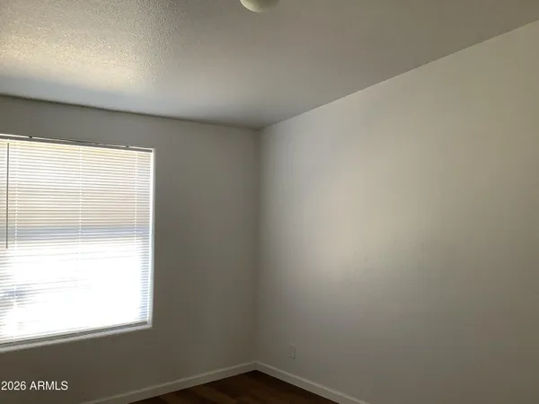 a view of an empty room with wooden floor and a cabinet
