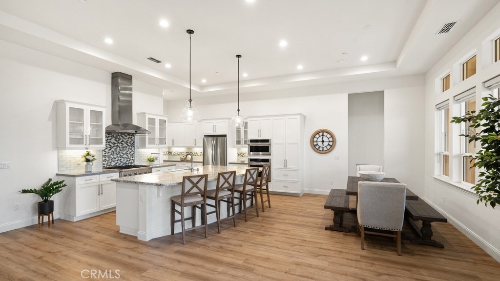851 Trail View Place Nipomo, CA 93444 - Photo 11 of 47 a kitchen with stainless steel appliances granite countertop a stove top oven a sink dishwasher a dining table and chairs with wooden floor